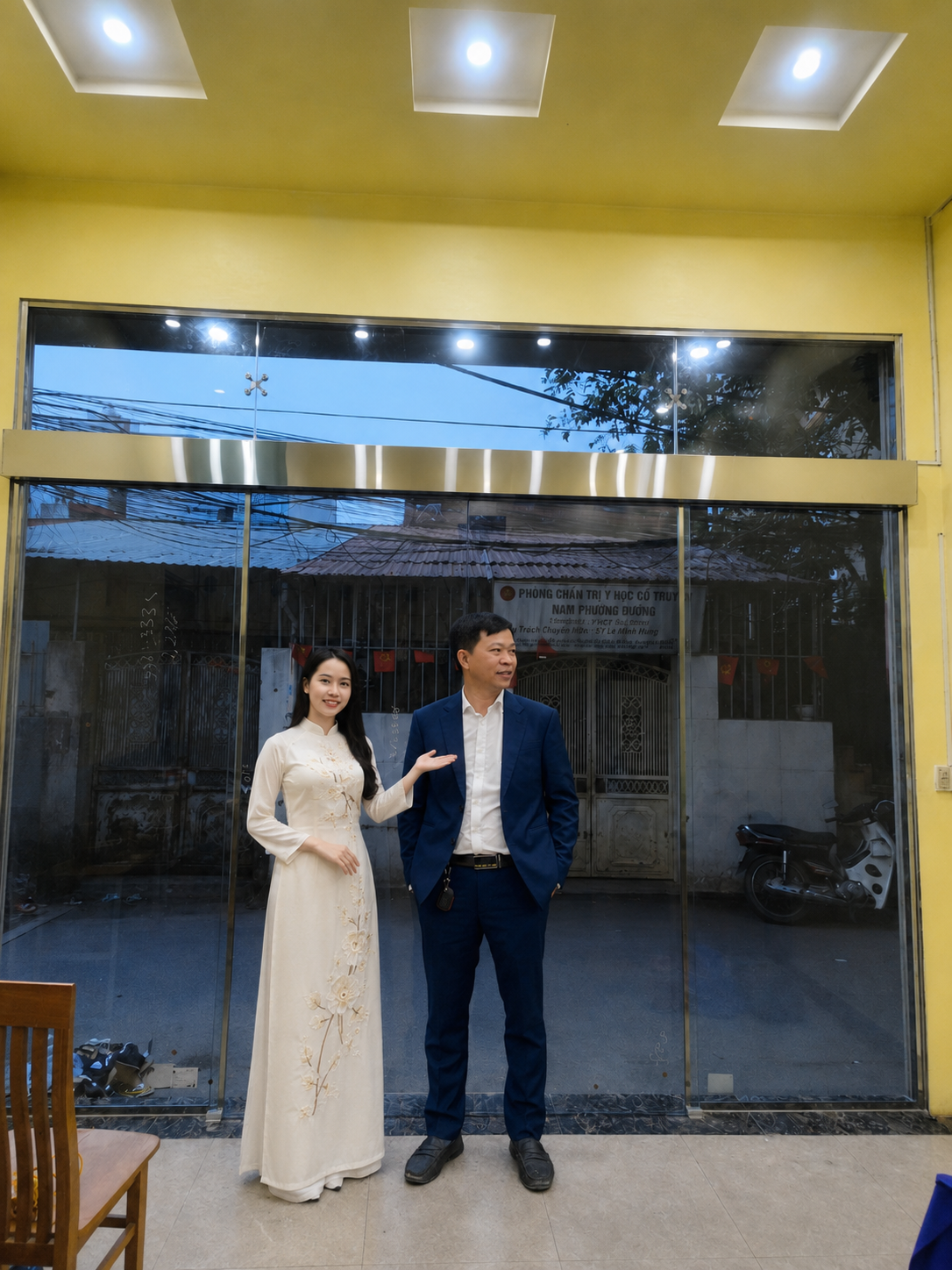 Cửa kính cường lực khung nhôm lớn trong nhà, phía trước có hai người đứng tạo cảm giác sang trọng